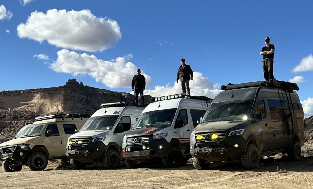 Group of Sprinter Vans with men standing on top posing for a fun photo